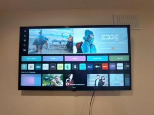 a flat screen tv hanging on a wall at Cosy London Family apartment for 4 persons near Westfield Shepherd's Bush in London