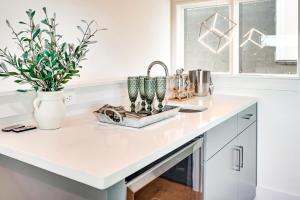 a kitchen counter with two vases and a sink at The Duo - 24 Beds & Stunning City Views Rare Find in Nashville