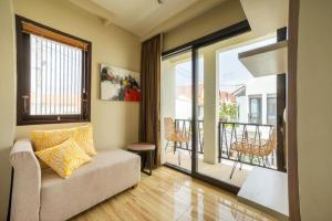a living room with a couch and a balcony at Comfortable Villa in Quiet Area in Nusa Dua