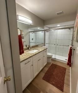 ein Badezimmer mit einem Waschbecken, einem WC und einem Spiegel in der Unterkunft Lake View Meadows Condo in Sarasota