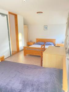 a bedroom with two beds and a table at Auberge le bois du cornet in La Forclaz