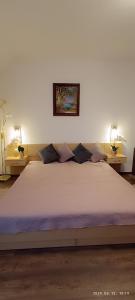 a bedroom with a large white bed with two lamps at Borisz Apartman Zalakaros in Zalakaros