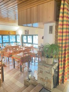un restaurante con mesas y sillas y una maceta en Auberge le bois du cornet en La Forclaz
