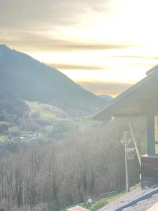 a building with a view of a valley with mountains at Auberge le bois du cornet in La Forclaz