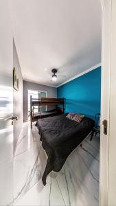 Vila BalneáriaにあるCantinho em Família - XF05Hの青い壁のベッドルーム1室(ベッド1台付)