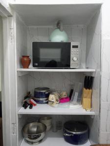 a microwave sitting on a shelf in a kitchen at Haven Apartment in Mombasa