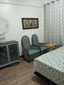 um quarto com duas cadeiras e uma cama e uma televisão em Haven Apartment em Mombasa