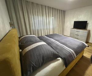 a bedroom with a bed and a dresser with a television at Apartment Lothse Shar in Dölsach