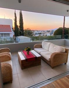 a living room with a couch and a table on a balcony at Hill Luxury Family Maisonette 21 in Ayios Dhometios