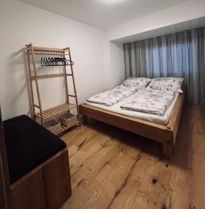 Schlafzimmer mit einem Bett und Holzboden in der Unterkunft Apartment Lothse Shar in Dölsach