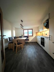 eine Küche und ein Wohnzimmer mit einem Tisch und Stühlen in der Unterkunft Apartment Lothse Shar in Dölsach