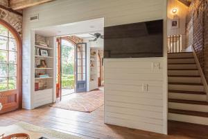 ein Wohnzimmer mit einer Treppe und einem TV in der Unterkunft Gibbon House at Casa Zoe in Charleston