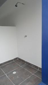 een kamer met een witte muur en een tegelvloer bij Villa Santorini in Cumaral