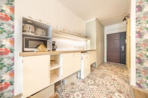 a kitchen with white cabinets and a tile floor at Valentina Apartment in CityCenter in Budapest