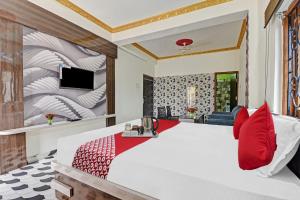 蘭契的住宿－OYO Flagship Hotel Jagat Palace，卧室配有带红色枕头的大型白色床