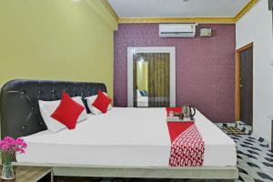 蘭契的住宿－OYO Flagship Hotel Jagat Palace，一间卧室配有一张带红色枕头的大床