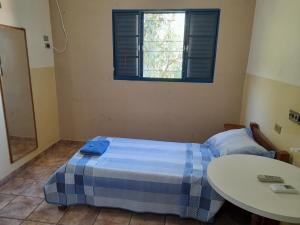 1 dormitorio con cama, mesa y ventana en HOTEL NOVO HOTEL, en Três Lagoas