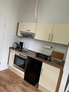 a kitchen with white cabinets and a black stove top oven at Cityliebe in Magdeburg