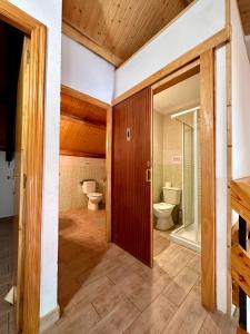 a bathroom with two toilets and a glass door at Albergue Valle de Arbas in Cubillas de Arbas