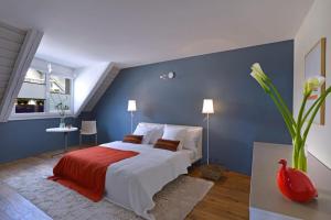 ein Schlafzimmer mit einem Bett und einer blauen Wand in der Unterkunft L'Eau Forte - maison d'hôtes in Saint-Blaise