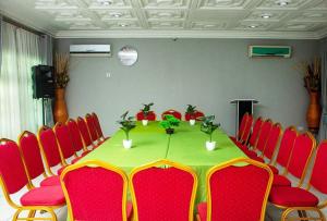 uma sala de conferências com uma mesa e cadeiras vermelhas em ULTIMATE HOTEL em Tokuse