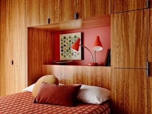 um quarto com uma cama com uma cabeceira e um candeeiro em Marmol Radziner's Modernist Cabin - Joshua Tree em Joshua Tree