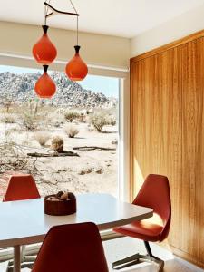uma sala de jantar com uma mesa e cadeiras vermelhas em Marmol Radziner's Modernist Cabin - Joshua Tree em Joshua Tree