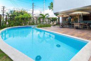 una gran piscina azul junto a una casa en Parque Shopping #2206 - Apartamento em Boa Viagem Housi por Carpediem en Recife
