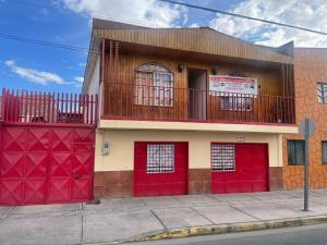 un edificio con puertas rojas de garaje en una calle en Hostal Las Ñipas, en Calama