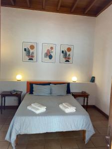 una camera con un letto con tre immagini appese al muro di Casa Origenes a Haría