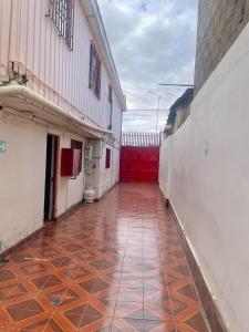 pusty korytarz budynku z podłogą wyłożoną kafelkami w obiekcie Hostal Las Ñipas w mieście Calama