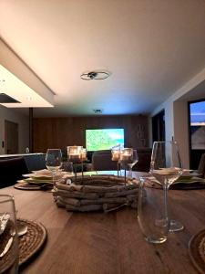 una mesa con copas de vino y TV en 2 bedrooms house with sauna terrace and wifi at Gembloux, en Gembloux