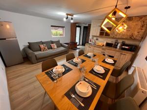 a kitchen and living room with a wooden table and chairs at View Piatra Craiului in Zărneşti