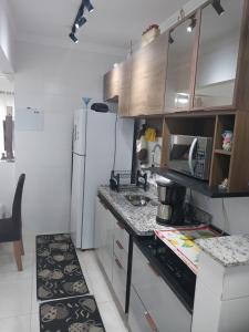 eine kleine Küche mit einer Theke und einem Kühlschrank in der Unterkunft Residencial Innovare 1 in Praia Grande