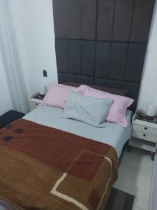 ein Schlafzimmer mit einem großen Bett mit rosa Kissen in der Unterkunft Residencial Innovare 1 in Praia Grande