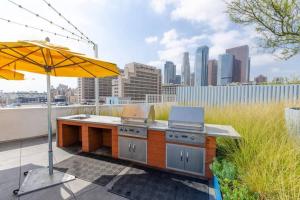 a patio with an outdoor kitchen with an umbrella at Cozy 3bed Condo with balcony & a rooftop pool in Los Angeles