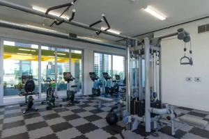 a gym with treadmills and ellipticals on a checkered floor at Cozy 3bed Condo with balcony & a rooftop pool in Los Angeles