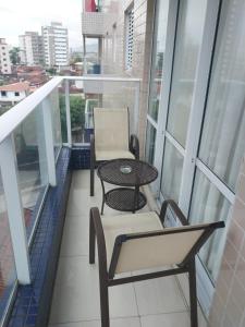 einen Balkon mit einem Tisch und Stühlen auf einem Gebäude in der Unterkunft Residencial Innovare 1 in Praia Grande
