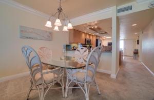 a dining room and kitchen with a table and chairs at Spectacular Sunsets at this Beachfront Condo in Bradenton Beach