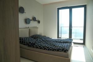 a bedroom with a bed and a large window at PREMIUM Apartment in center of Katowice in Katowice