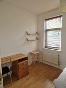1 dormitorio con escritorio, 1 cama y ventana en Suite 2: Chic Room near City Centre en Sheffield