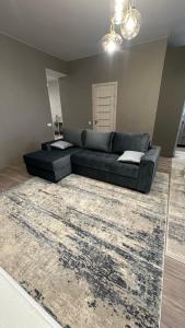 a black couch in a living room with a rug at Apartment in center of Chisinau in Chişinău