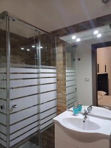 een badkamer met een wastafel en een douche bij Appartamento fronte porto in Alghero