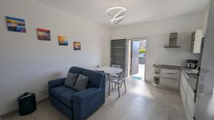 sala de estar con sofá azul y mesa en Leporano villa MADIA con piscina, Taranto, en Leporano Marina