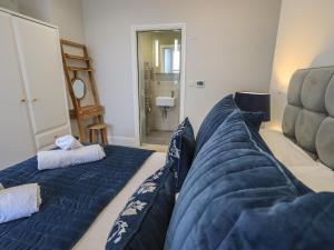 ボウネス・オン・ウィンダミアにあるPartridge at Stonecliffeのベッド2台、ソファ、鏡が備わる客室です。