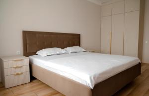 a bedroom with a large bed with white sheets at Новая 2х комнатная ЛЮКС квартира в центре in Kokshetau