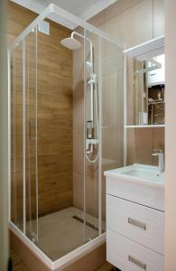 La salle de bains est pourvue d'une douche avec une porte en verre. dans l'établissement Новая 2х комнатная ЛЮКС квартира в центре, à Kökşetaw