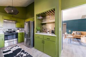 a kitchen with green cabinets and a refrigerator at The Lounge Off Lindsay in Norman