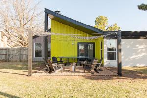 a yellow house with a picnic table in front of it at The Lounge Off Lindsay in Norman