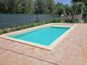una piscina en un patio con una entrada de ladrillo en Leporano villa MADIA con piscina, Taranto, en Leporano Marina